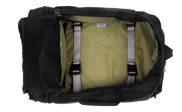 An open Techonaut 30 with a Black exterior and a Taiga (sage green) interior.
